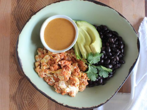 Shrimp with avocado, black beans, and sauce on a plate.