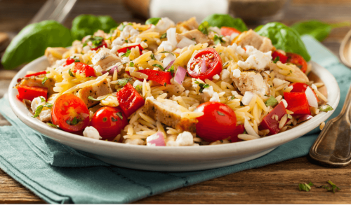 A colorful salad with tomatoes, onions, and herbs on a white plate.